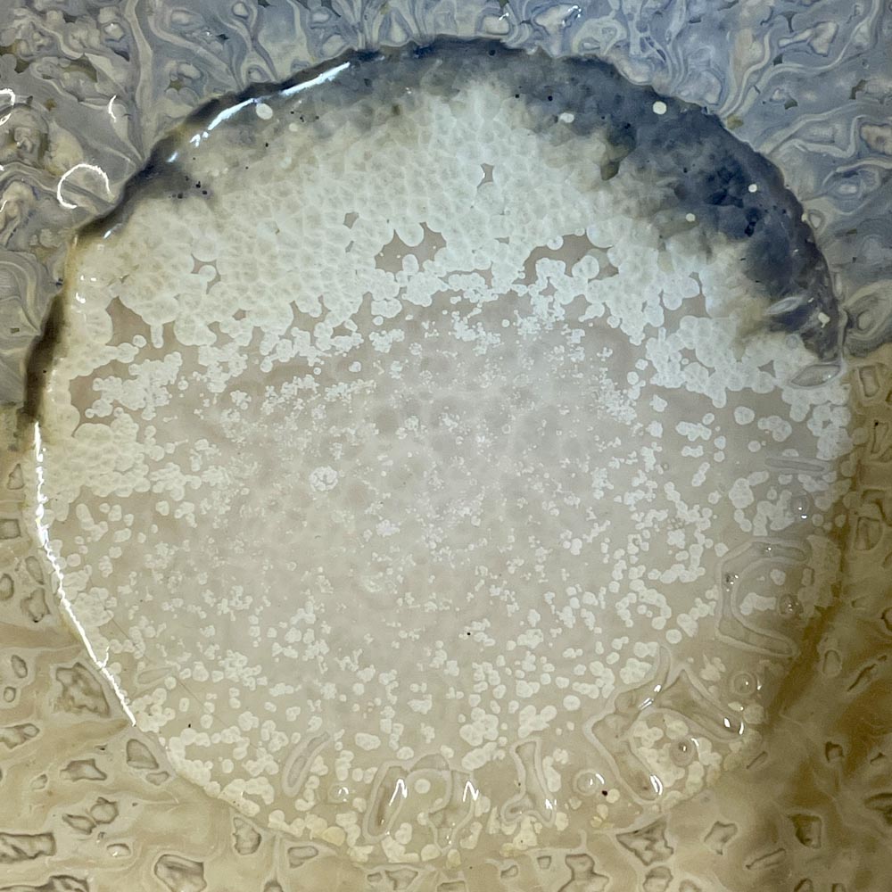 A close up of blue and ivory crystalline glaze.